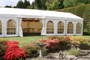 A lined marquee in a garden in Farnham for a birthday party.