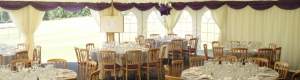 A lined marquee with Georgian window walls, with furniture set up for a wedding reception